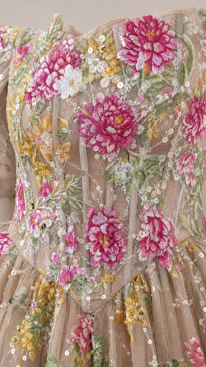 Close-up detail of bodice showing pink and yellow floral embroidery, boning, and sequin accents