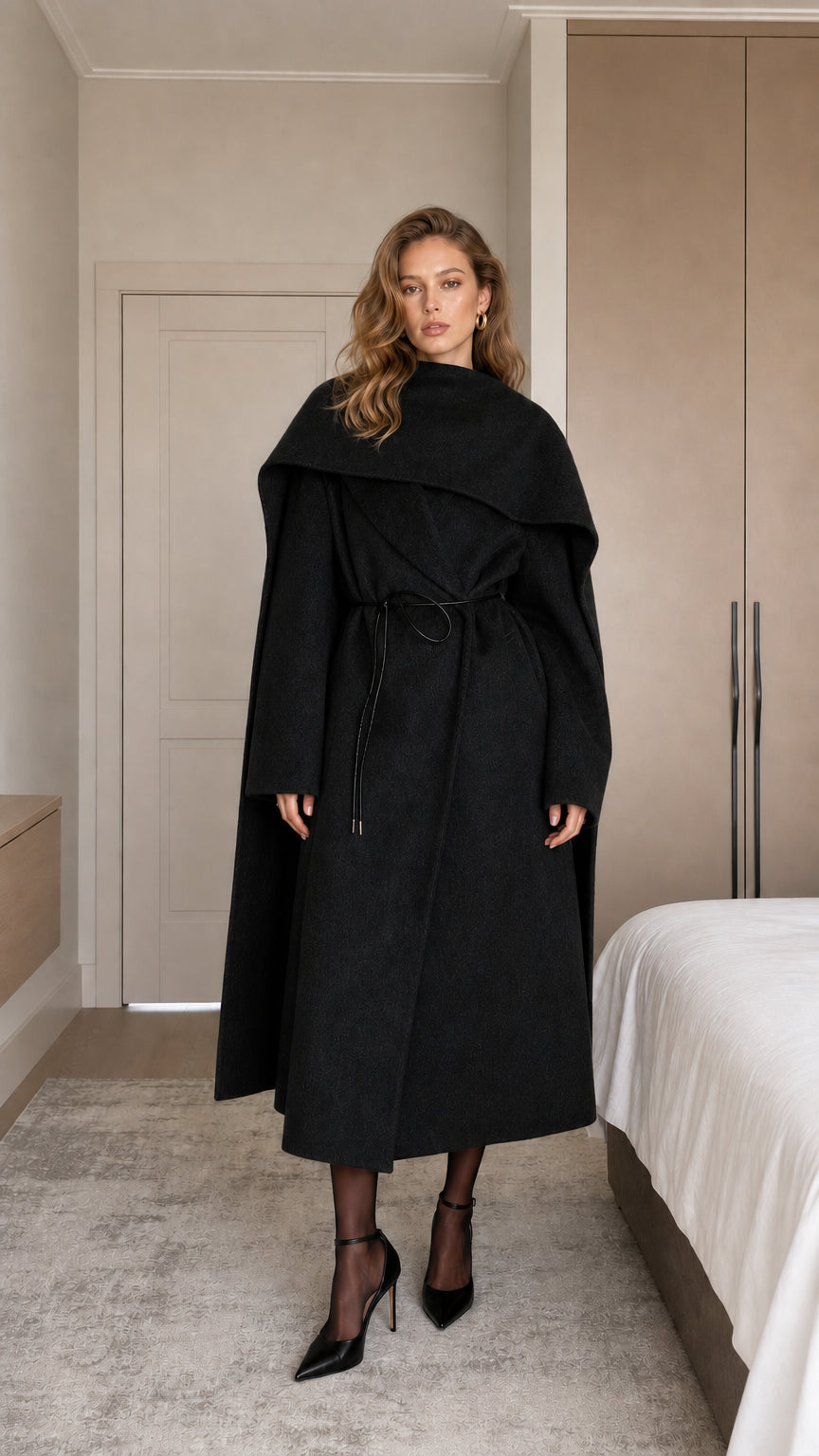 Model wearing black draped cape collar maxi coat