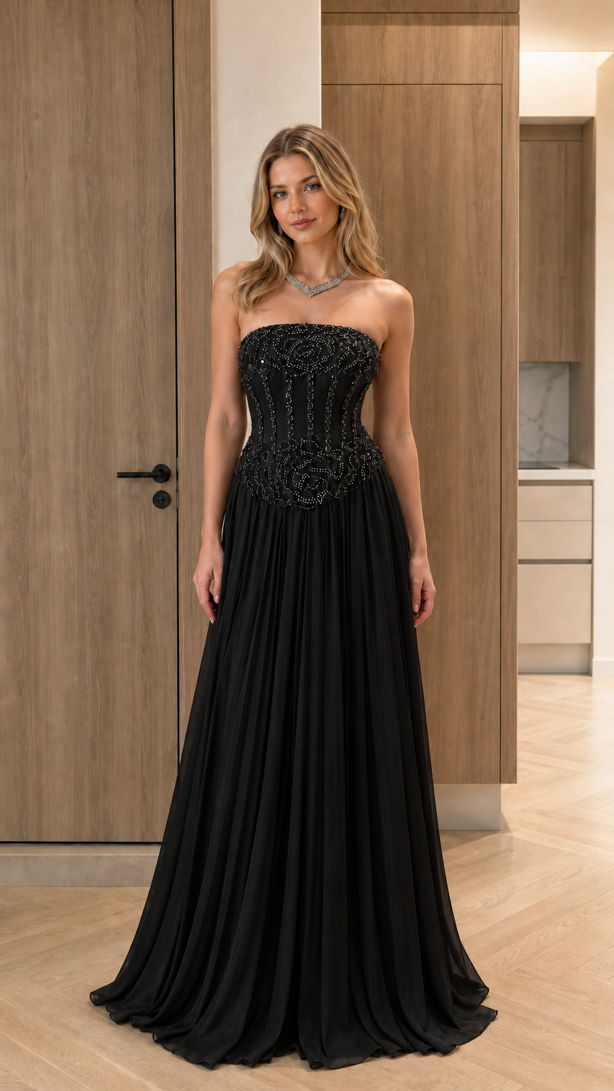 Model wearing classic black strapless beaded corset pleated evening gown