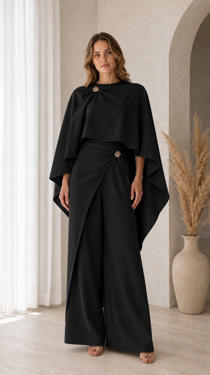 Front view of model wearing Black elegant capelet top and matching wide-leg trousers
