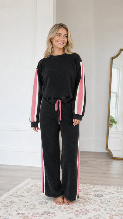 Front view of model wearing the Washed Black wide-leg sweatsuit set with pink and white side stripes