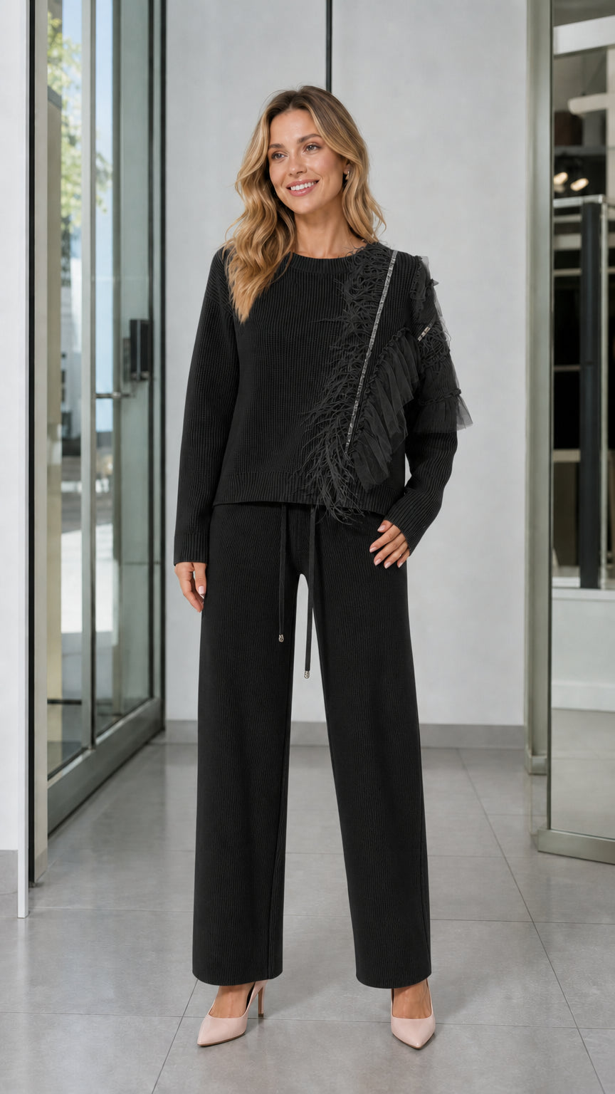 Full-length front view of woman wearing Black feather trim knit sweater and wide-leg pants set