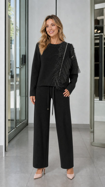 Full-length front view of woman wearing Black feather trim knit sweater and wide-leg pants set