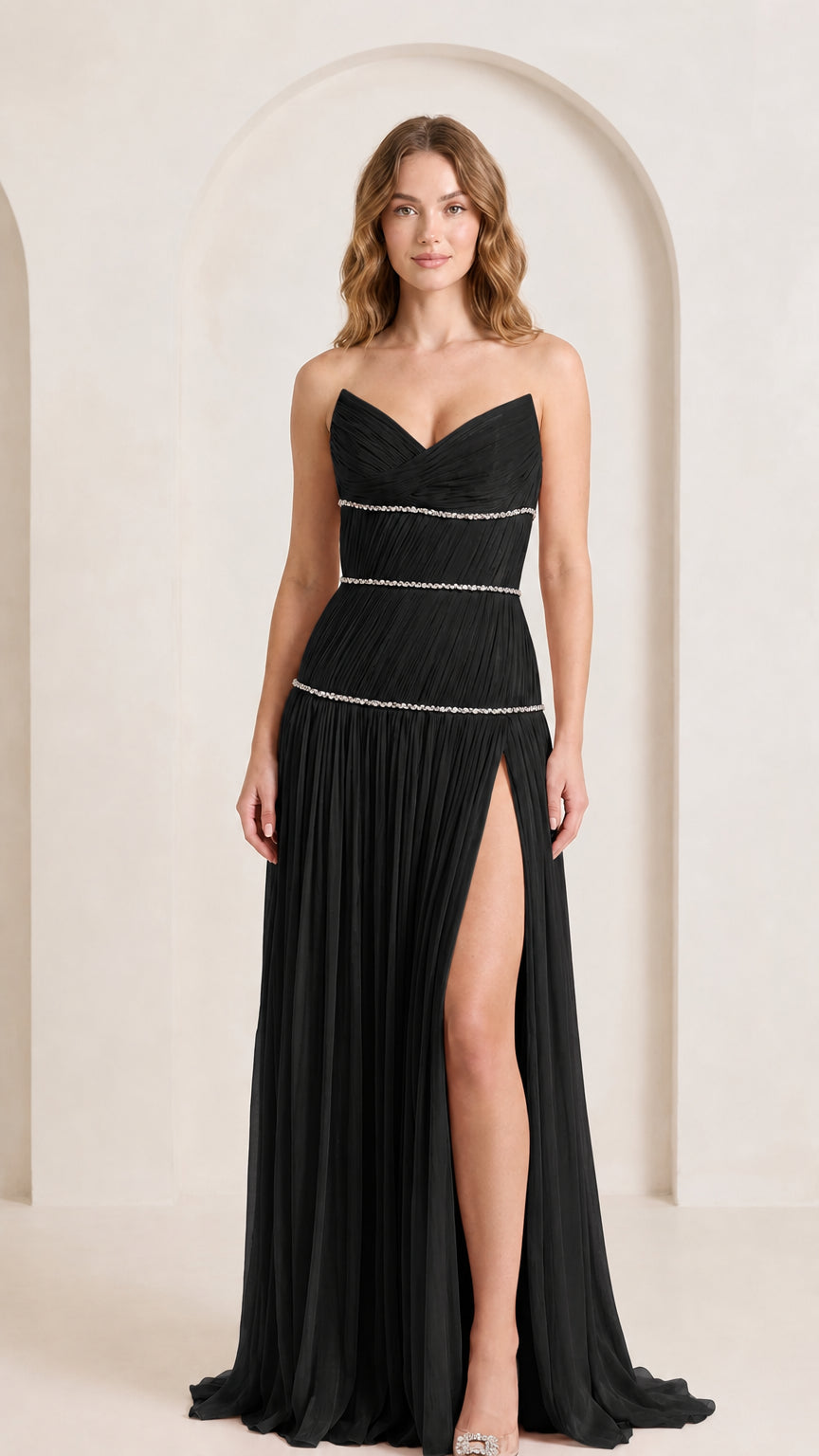Front view of woman wearing black strapless pleated evening gown with rhinestone details