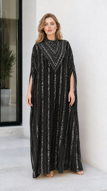 Model wearing black sequin embellished cape sleeve kaftan evening dress