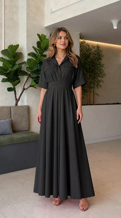 Front full view of woman wearing classic black collared pleated maxi dress