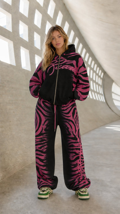 Full front view of model wearing black and magenta pink graphic tracksuit set