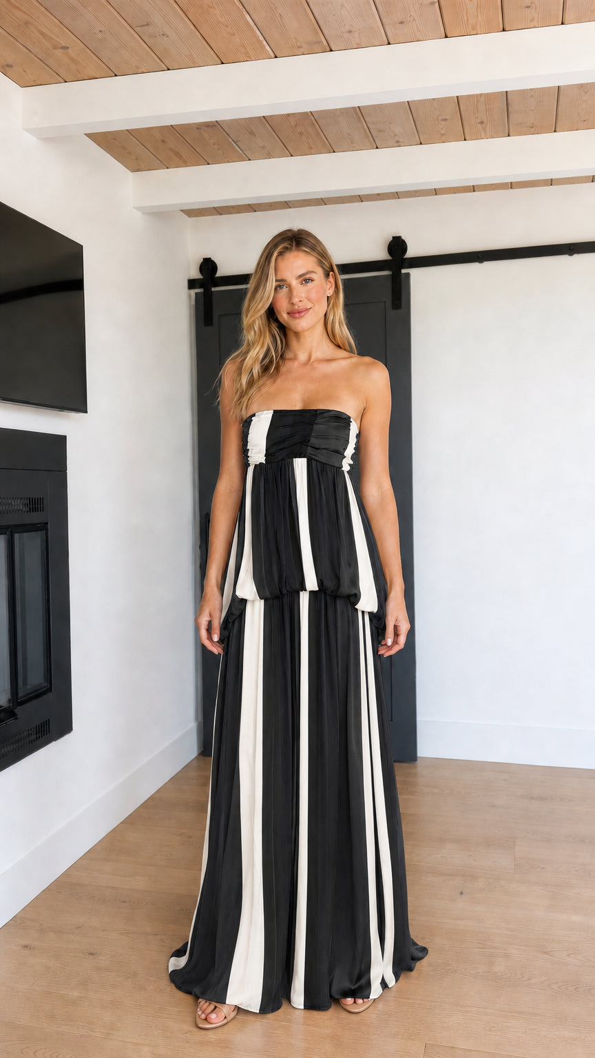 Front view of model wearing Black and White striped strapless maxi dress