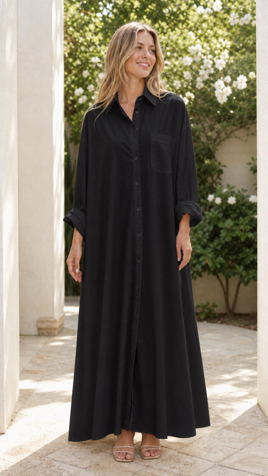 Woman wearing full-length black oversized button-front maxi shirt dress