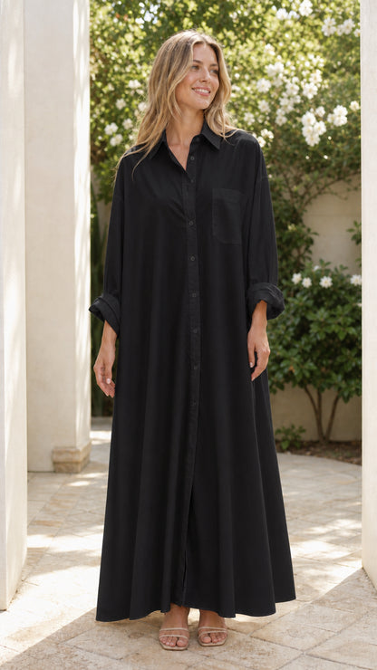 Woman wearing full-length black oversized button-front maxi shirt dress