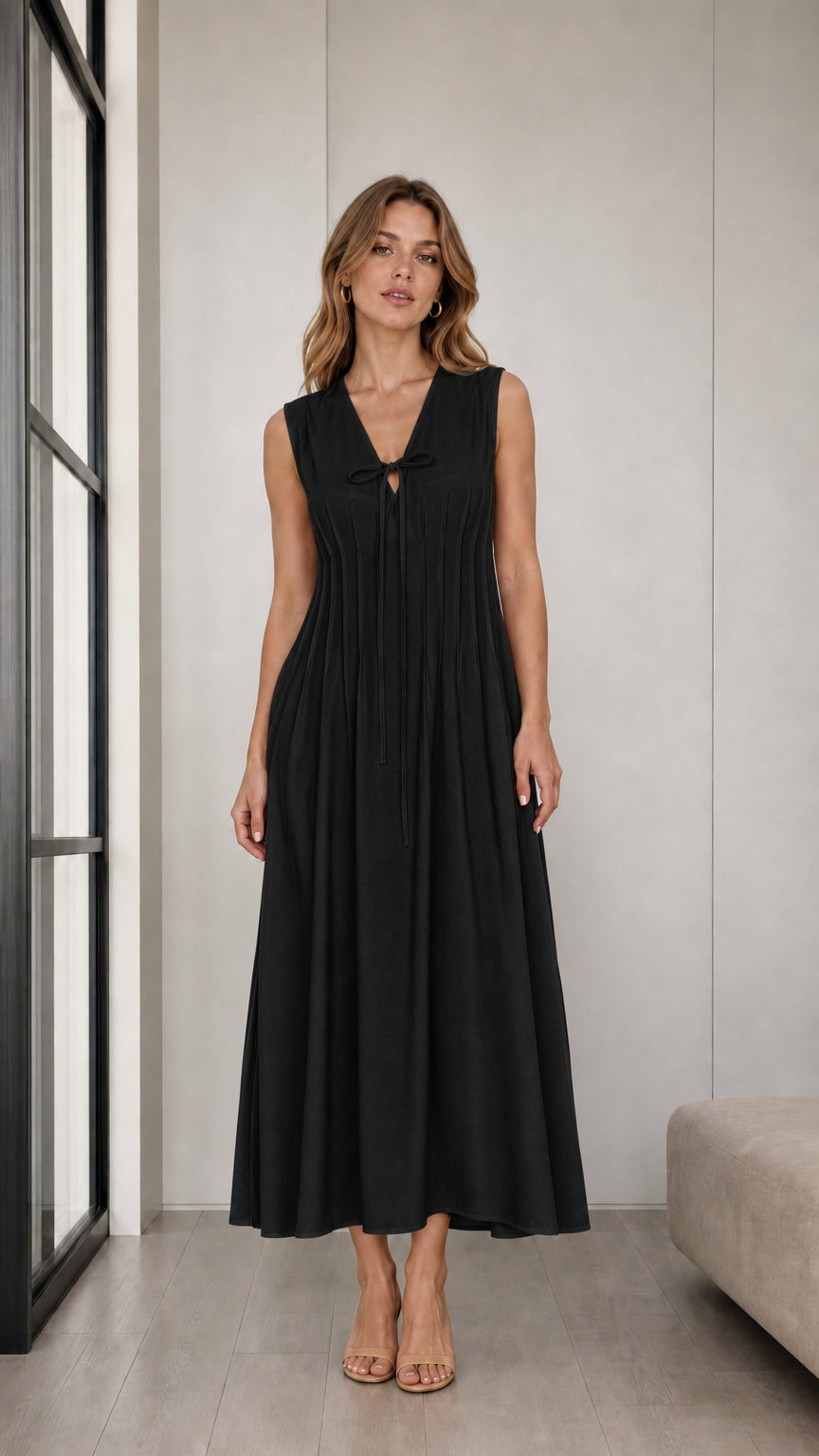 Front view of woman wearing Black sleeveless pleated tie-neck midi dress