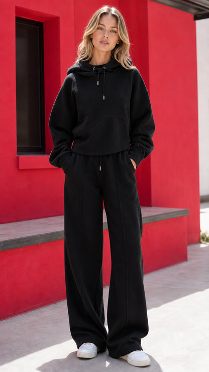 Woman wearing black two-piece hoodie and wide-leg sweatpants set