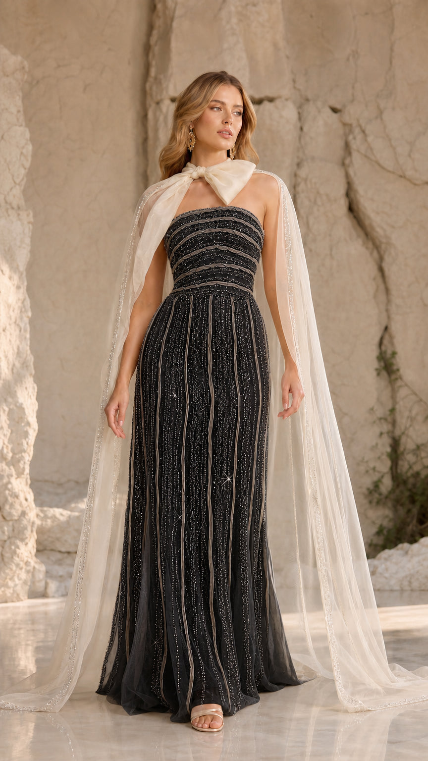 Black strapless beaded evening gown paired with contrasting ivory tulle cape