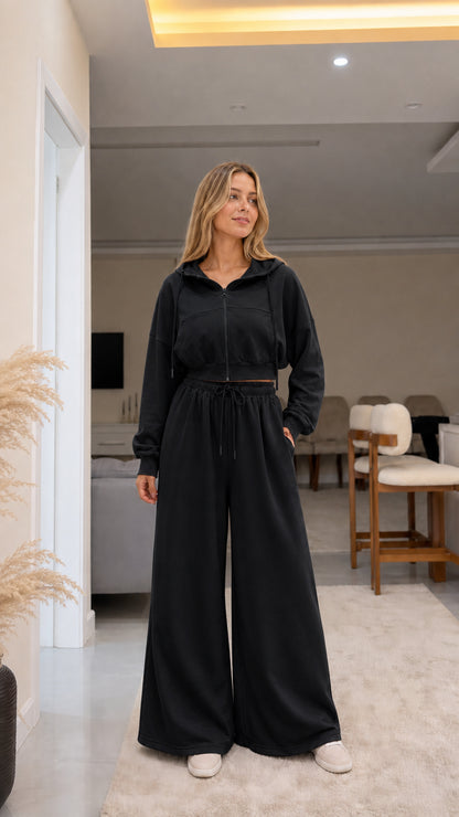 Model wearing black cropped zip hoodie and wide-leg sweatpants set