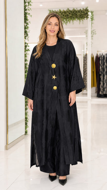 Front view of black textured jacquard maxi abaya with gold buttons