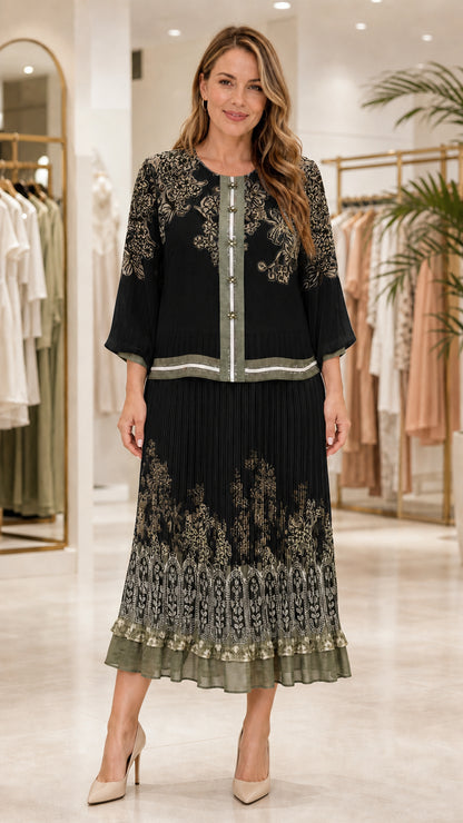 Model wearing black floral print blouse and matching pleated midi skirt set
