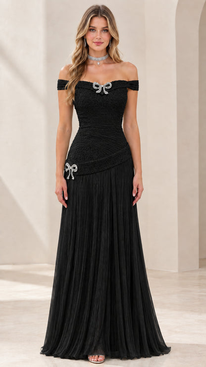 Full-length view of black off-the-shoulder pleated evening gown