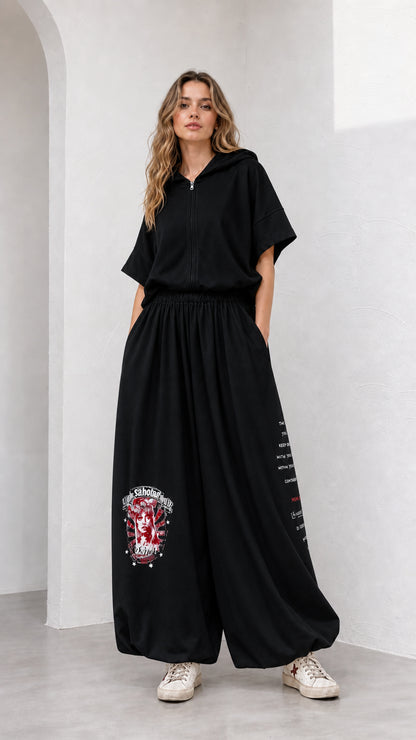 Model wearing black short-sleeve hooded top and matching balloon pants set