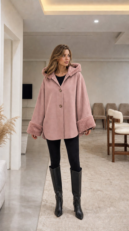 Model wearing dusty pink hooded cape coat with faux fur trim