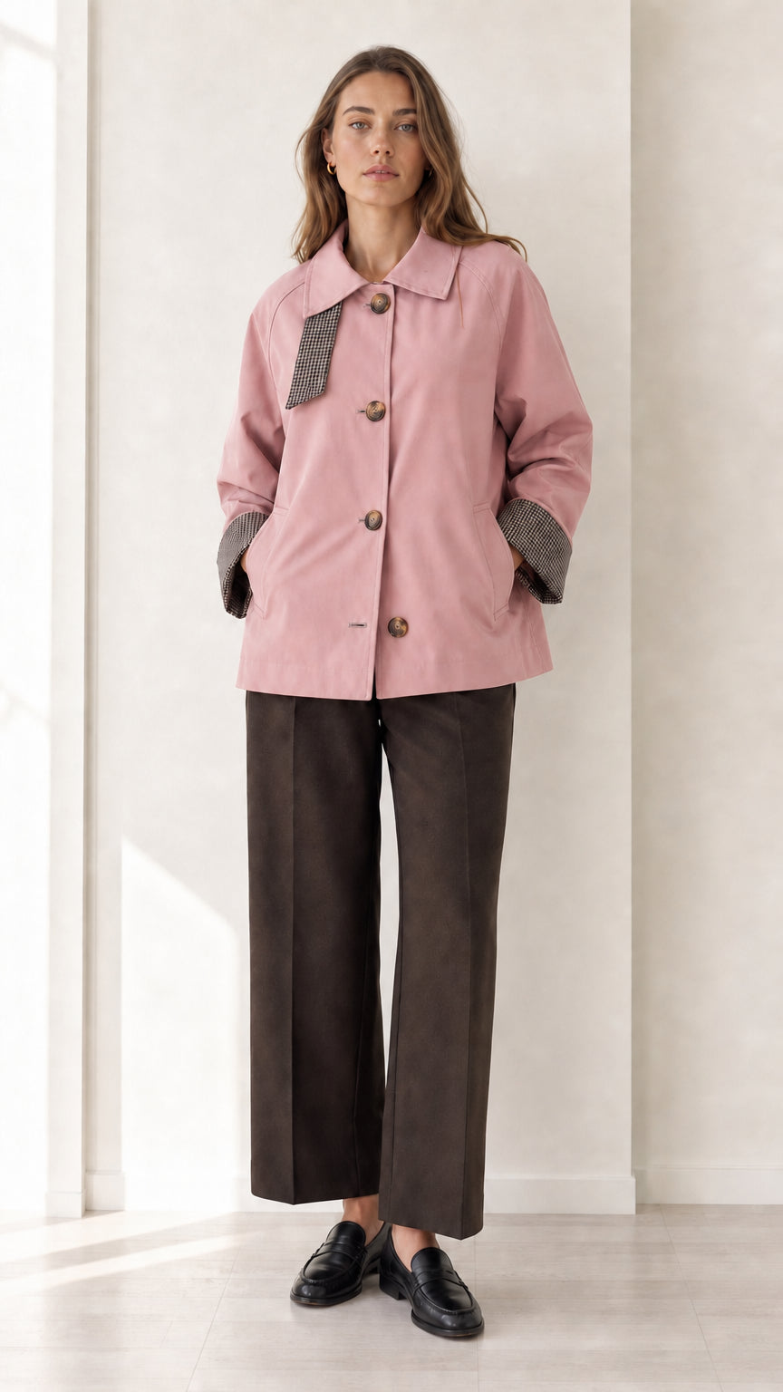 Front view of women's dusty pink short trench coat with check trim details