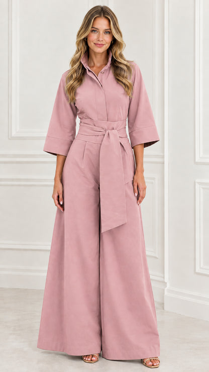 Front view of woman wearing a dusty pink collared wide-leg jumpsuit with belt
