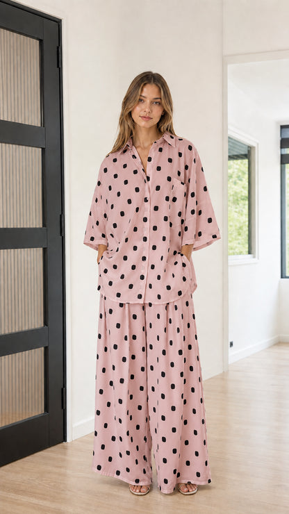 Front view of model wearing dusty pink and black polka dot two-piece matching set