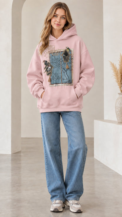 Front view of woman wearing light pink vintage nature bird graphic hoodie