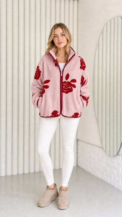 Model wearing dusty pink fleece jacket with red floral pattern
