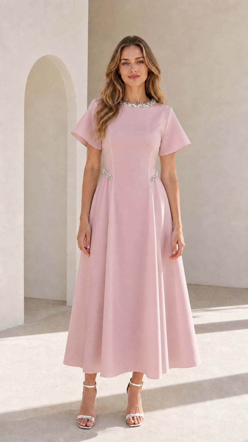 Front view of woman wearing blush pink pearl embellished A-line midi dress