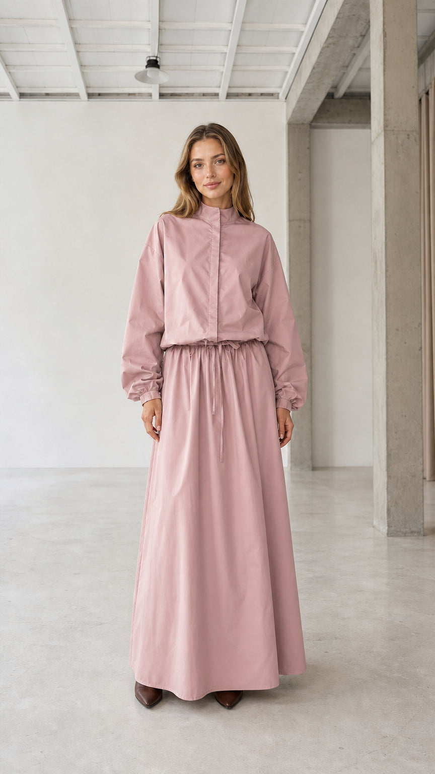 Front view of woman wearing dusty pink long sleeve stand collar drawstring maxi dress