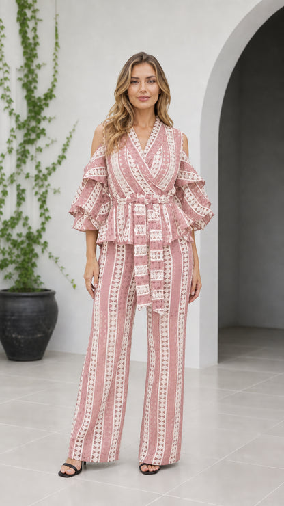 Front view of woman wearing dusty pink geometric cold shoulder wide-leg jumpsuit