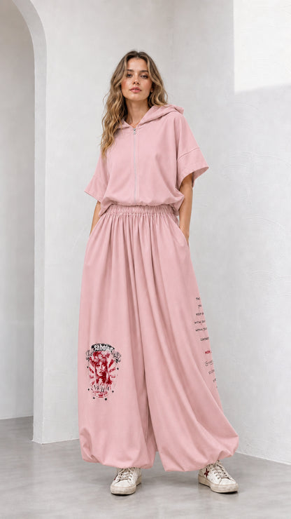 Model wearing dusty pink short-sleeve hooded top and wide-leg graphic pants set
