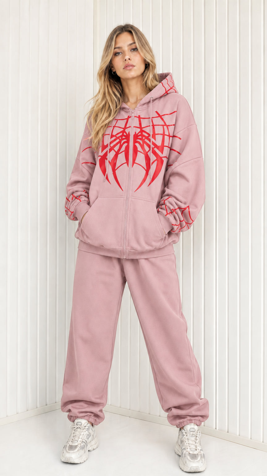 Front view of model wearing dusty pink graphic spider web zip hoodie and sweatpants set