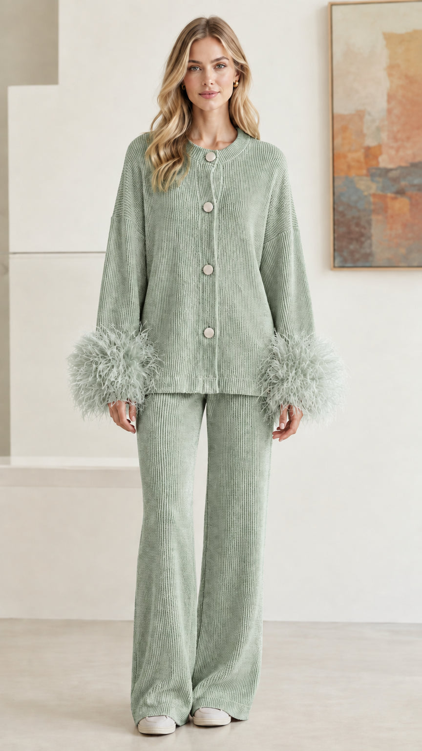 Front view of model wearing sage green ribbed knit cardigan and wide-leg pant set with feather cuffs