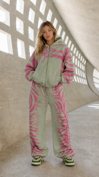 Full front view of model wearing sage green and pink graphic tracksuit set