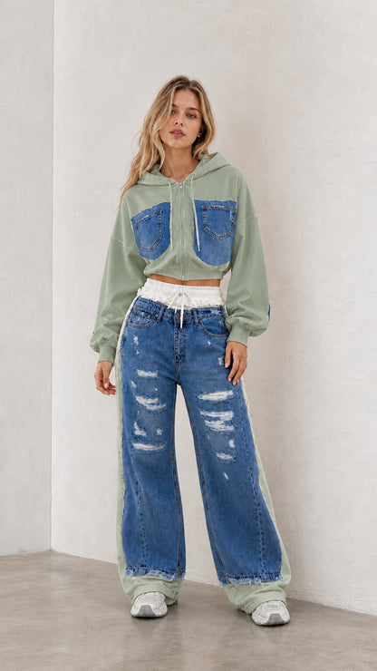 Model wearing sage green cropped zip hoodie and blue denim spliced wide leg pants set