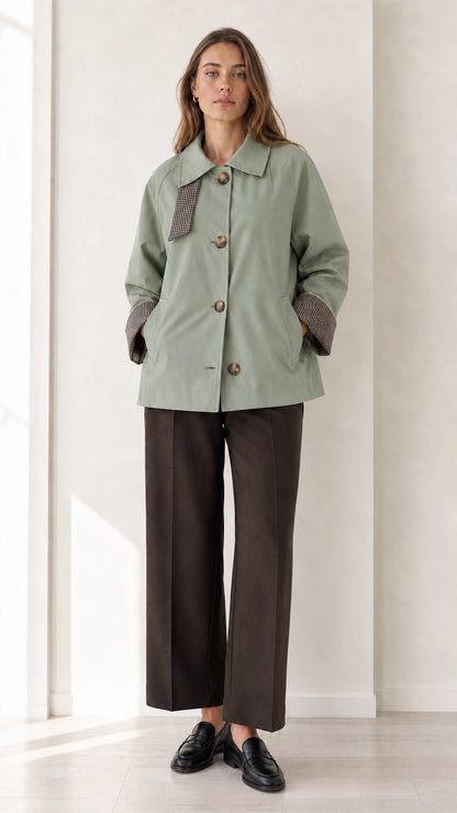 Front view of women's sage green button-up short trench jacket