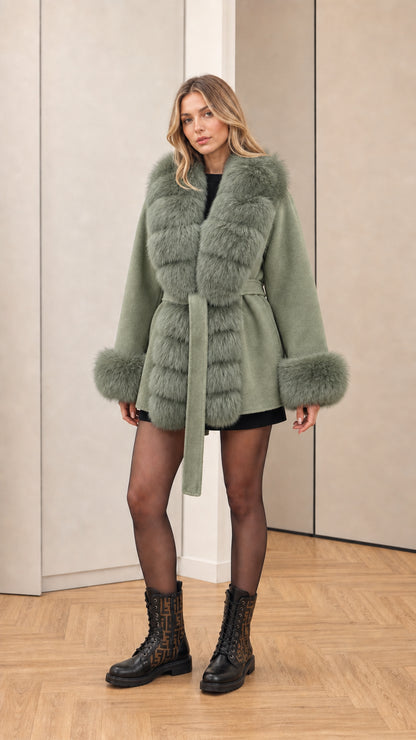Model wearing sage green hooded faux fur trim belted wrap coat