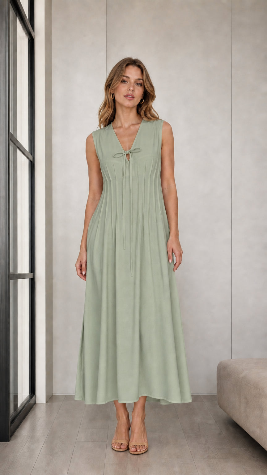 Front view of woman wearing Sage Green sleeveless pleated tie-neck midi dress