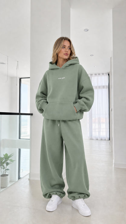 Full-length view of model wearing the sage green fleece tracksuit set