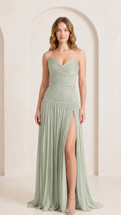 Front view of woman wearing sage green strapless pleated formal gown with side slit