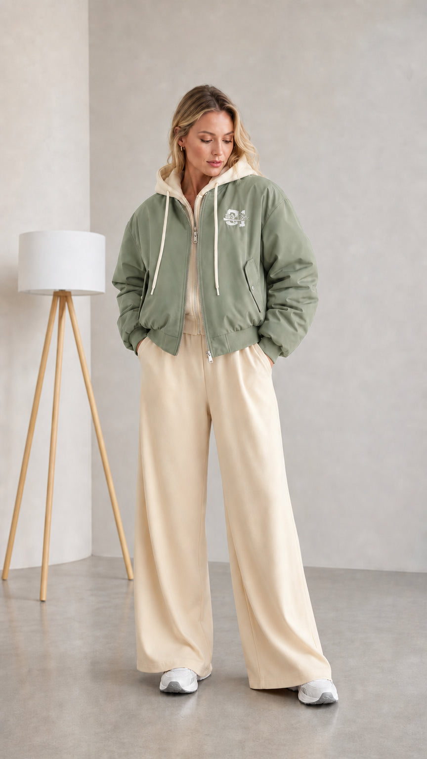 Woman wearing sage green layered hooded bomber jacket