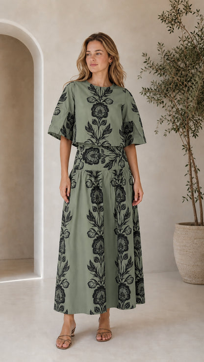 Woman wearing sage green floral print two-piece top and maxi skirt set
