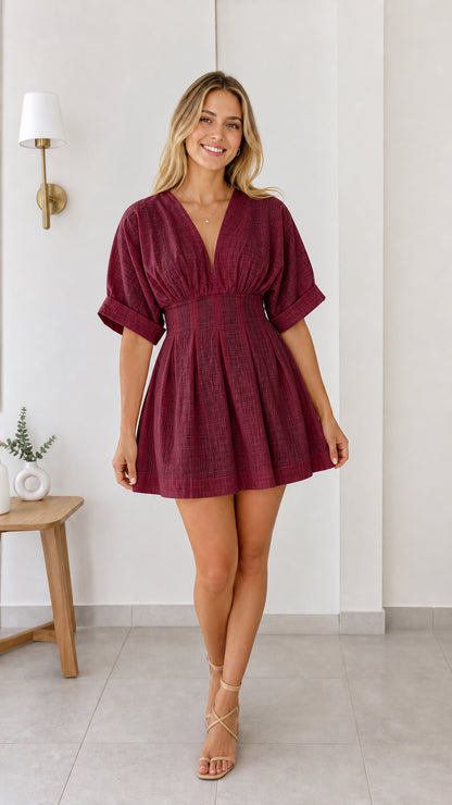 Model wearing burgundy red short sleeve pleated mini dress