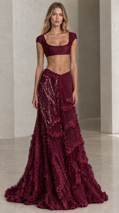Front view of model wearing burgundy two-piece formal crop top and textured maxi skirt