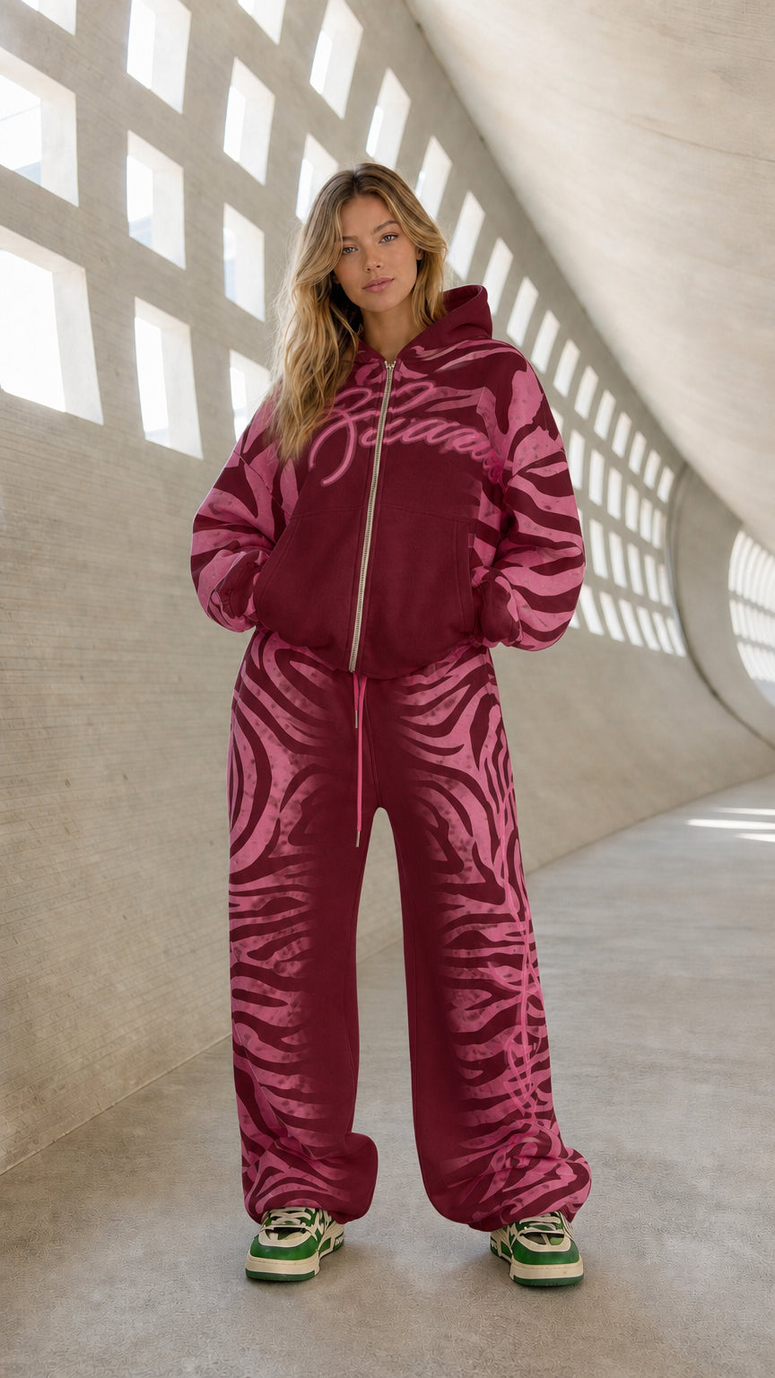 Full front view of model wearing burgundy and pink graphic tracksuit set