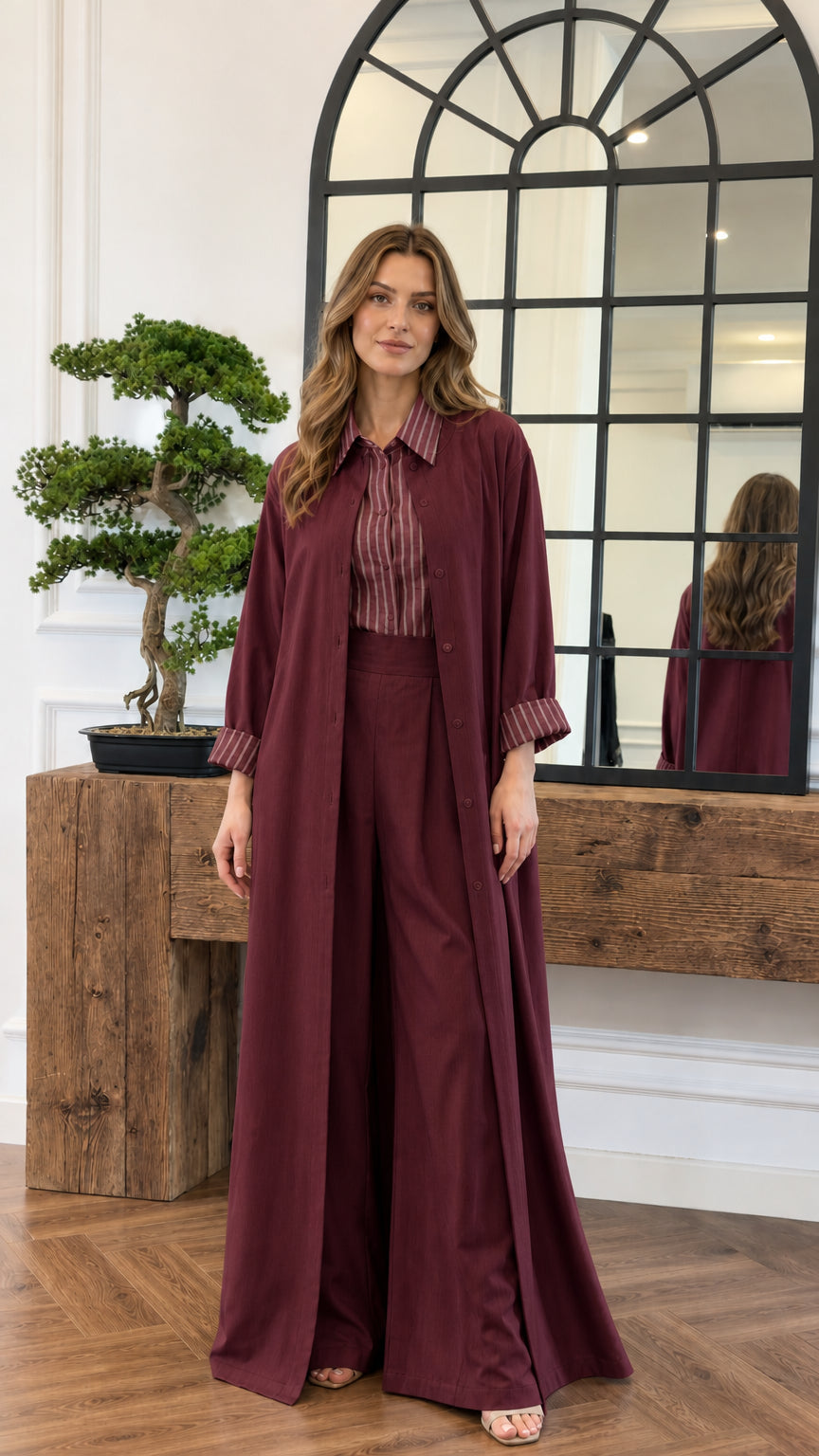 Model wearing the burgundy 3-piece duster, striped blouse, and pant set