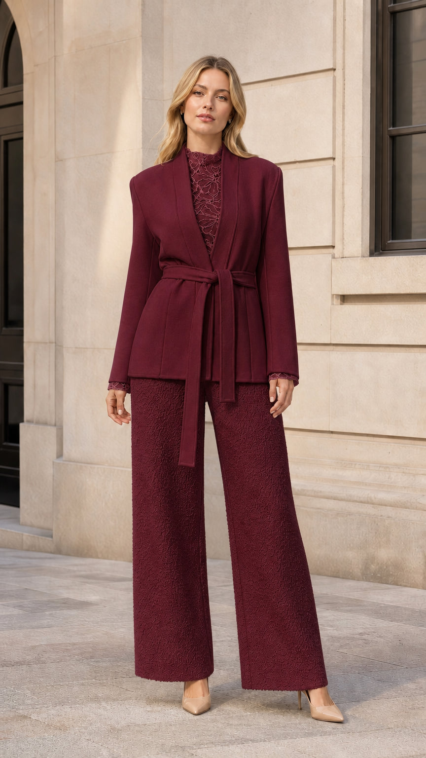 Front view of model wearing burgundy belted blazer jacket with matching trousers