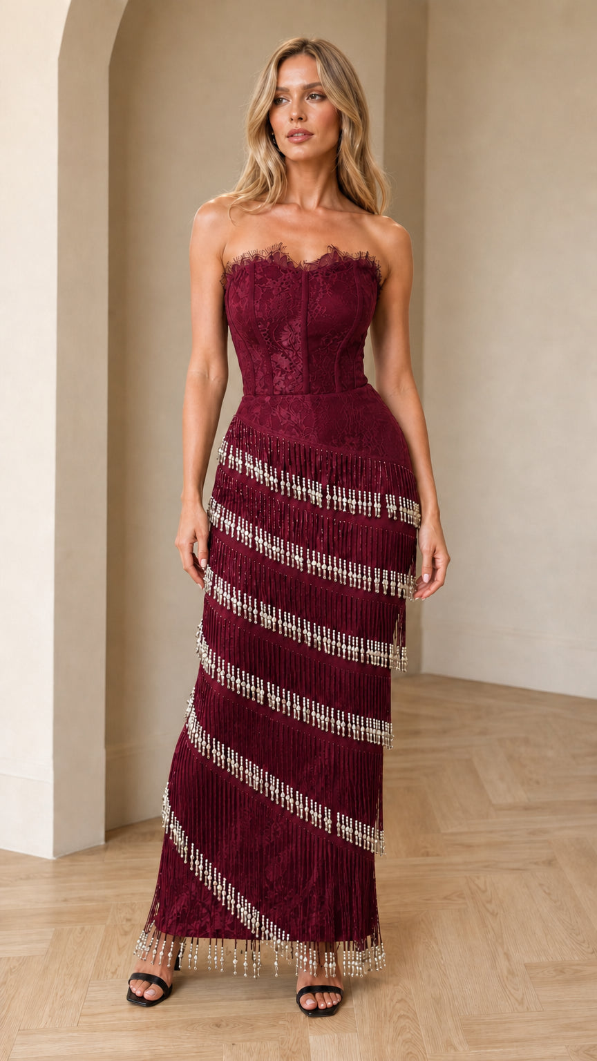 Model wearing burgundy wine strapless lace corset beaded fringe maxi dress