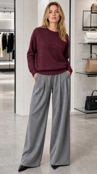 Model wearing burgundy wine crewneck knit sweater with grey wide-leg trousers
